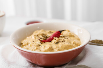 Bowl of tasty chicken curry on table, closeup