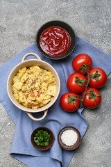 Pot of tasty chicken curry and ingredients on grunge background