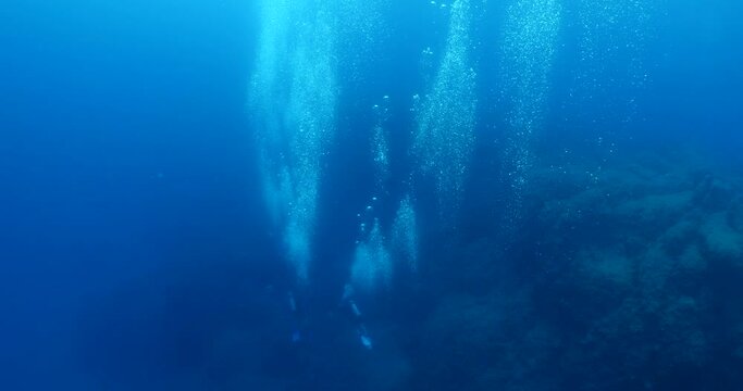 scuba divers scenery underwater with air bubbles in blue ocean