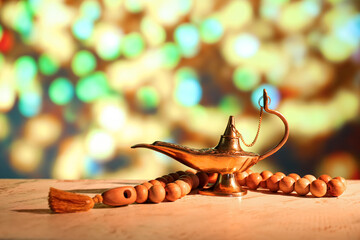 Aladdin lamp of wishes with tasbih against blurred lights