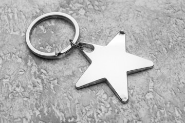 Silver star shape keychain on grunge background