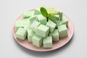 Plate with tasty sweet marshmallows on light background