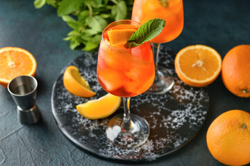 Glasses of tasty aperol spritz cocktail on dark background