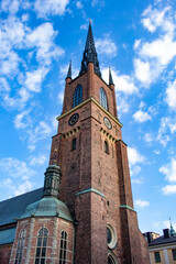 Fototapeta na wymiar The Beautiful Brick Steeple of the Riddarholmen Church Is Contrasted against the Deep Blue Sky in Stockholm, Sweden