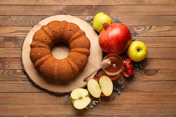 Bread with honey, pomegranate and apples on wooden background. Rosh hashanah (Jewish New Year) celebration