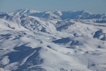 A view of a snow covered mountain in Chile with clear sky after the storm