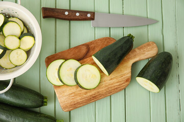 Board with sliced zucchini squash on color wooden background