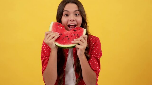 surprised hungry kid eating slice of water-melon fruit on yellow background, watermelon