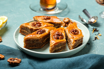Plate with tasty baklava on blue background