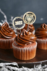 Plate with tasty cupcakes for New Year 2022 celebration, closeup