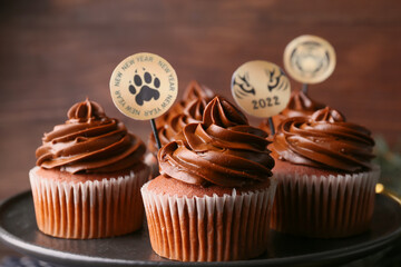 Plate with tasty cupcakes for New Year 2022 celebration, closeup