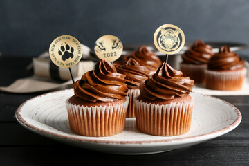 Plate with tasty cupcakes for New Year 2022 celebration on table