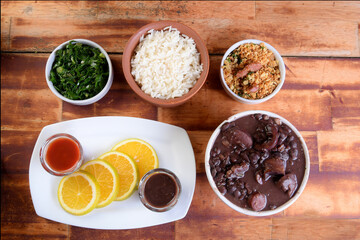 delicious Brazilian food feijoada with beans, pork, bacon, sausage with cabbage, rice, salad, spices and pepper. rustic cuisine.