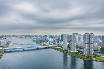 Fototapeta na wymiar 豊洲から見た東京の都市風景 Tokyo cityscape with cloudy sky.