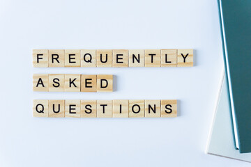 FAQS or Frequently asked questions word made with building blocks isolated on white. Wooden blocks with the word FAQ