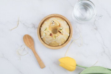 Fototapeta na wymiar Homemade lemon cake classic recipe, decorated with sugar icing on marble table. Healthy organic summer dessert pie with yellow tulip on background. 