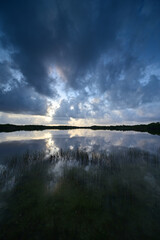 Colorful sunrise cloudscape reflected in calm water of Nine Mile Pond in Everglades National Park, Florida in summer.