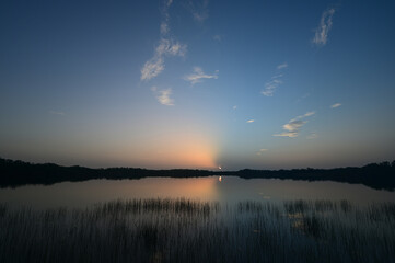 Colorful sunrise cloudscape reflected in calm water of Nine Mile Pond in Everglades National Park, Florida in summer.