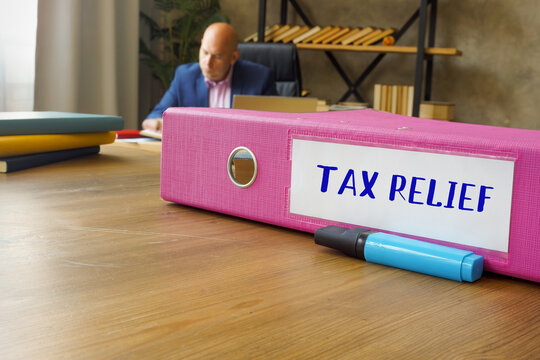 Inscription TAX RELIEF On The Box File. Businessman Working With Documents In Office