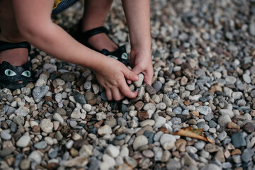 Closeup of child's hands playing in rocks on a beach