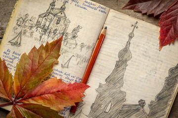 Vintage expedition journal on a rustic picnic table with a colorful leaf. Travel log from paddling...