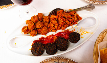 Tasty hot spanish snack from blood sausage with chorizo, picadillo and roasted pepper