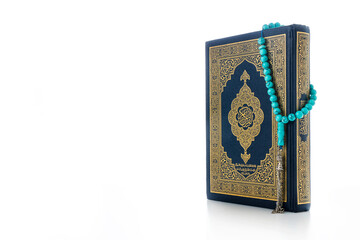 Islamic concept - The Holy Al Quran with written Arabic calligraphy meaning of Al Quran and rosary beads or tasbih, Arabic word translation: The Holy Al Quran (holy book of Muslims)