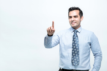 An Asian working man in an office suit stands pointing with a finger, on white background, with copy space.