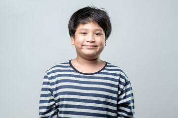 Portrait of a cute Asian boy smiling with happiness, on white background.