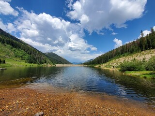 Upper Urad Reservoir in Arapaho National Forest, Colorado under sunny summer cloudscape.