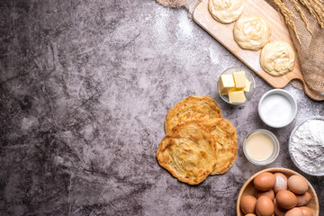 Roti pictures of Indian and Muslim food. And various ingredients such as eggs, flour, sugar, butter, sweet milk, and cooking tools are all on the old table, with copy space.
