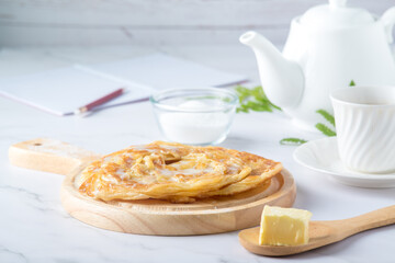 Roti pictures of Indian and Muslim food. and afternoon tea set, and there is sweet milk butter and sugar on the white table.