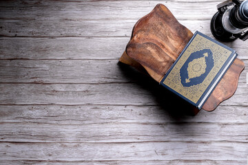 Islamic concept - The Holy Al Quran with written Arabic calligraphy meaning of Al Quran, on wooden...