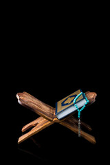 Islamic concept - The Holy Al Quran with written Arabic calligraphy meaning of Al Quran and rosary beads or tasbih, Arabic word translation: The Holy Al Quran (holy book of Muslim)