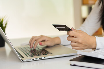 woman holding credit card and using laptop to work business people or entrepreneurs working, online shopping, ecommerce, concept internet banking, money spending, taxes