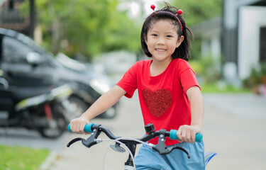 Obraz premium a girl ride a bicycle, kid happy and smile, asian child