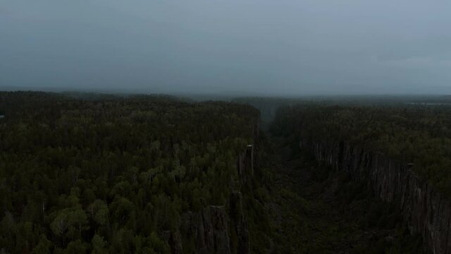 Aerial shot going through storm in Ouimet Canyon in 4K