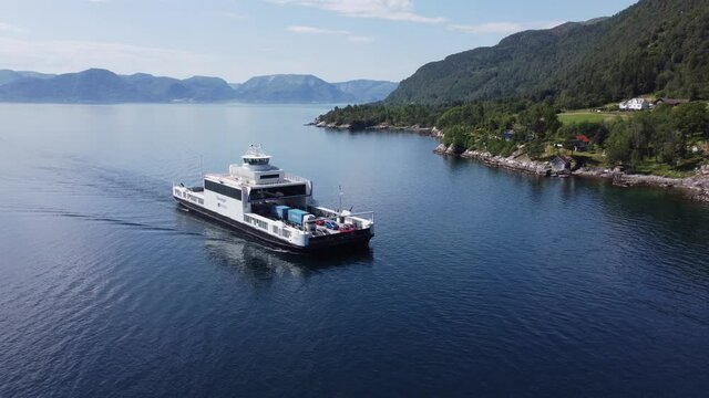Car and passenger ferry Mf Stavanger from company Norled transporting cars over the Sognefjord at E39 road between Oppedal and Lavik - Backwards moving sunny day aerial with ferry in center of frame