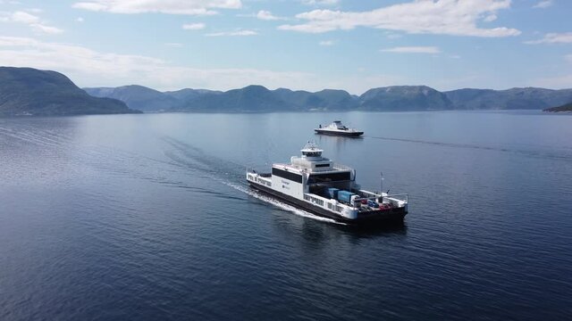 Following along ships side of Norled car ferry Mf Stavanger while crossing Sognefjord heading for Lavik - Aerial with ferry Oppedal in background - Norway