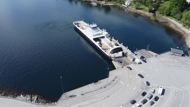 Ferry oppedal alongside Lavik ferry pier loading cars - Connecting european road E39 together - Sunny day aerial approaching ferry from far overview to near closeup - Norway