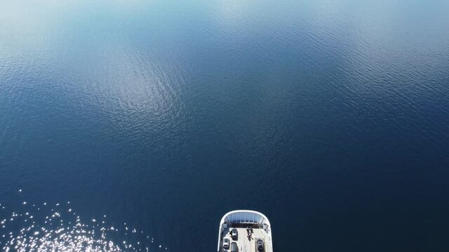 Car and passenger ferry MF Oppedal entering into frame from birdseye perspective - Beautiful sunny day with calm sea connecting road E39 between Oppedal and Lavik - Static aerial Norway
