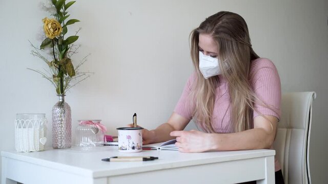 A young girl writes a letter to her lover in her apartment. Distance relationship.