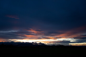 The sky is filled with beautiful white clouds. At sunset, the evening has warm light. Silhouette