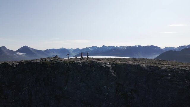Two People Hiking Along Ridge In The Mountains Of Innerdalen In Romsdal County, Norway - drone shot