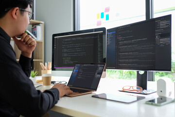 Asian man programmer working at at modern office. Developing programming..