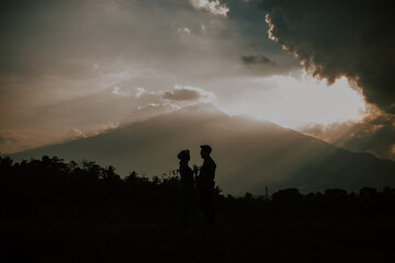 silhoutte of two lover sunset in the mountains