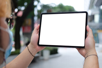 Close up view young man standing outdoor and using digital tablet.