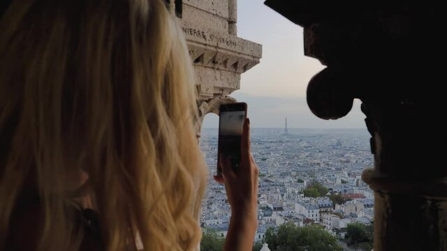 Blond woman taking photos with smart phone, Paris France Panorama