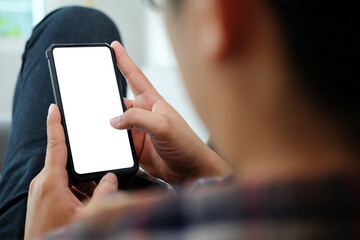 Close up view man using smart phone while sitting on sofa.
