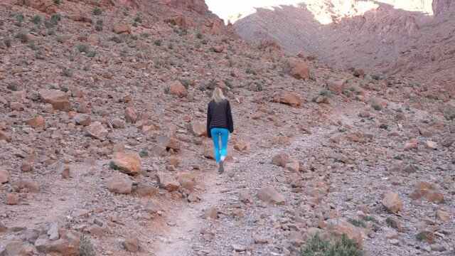 Back View Of A Woman Walking Uphill The Todra Gorges In Morocco. - Tracking
